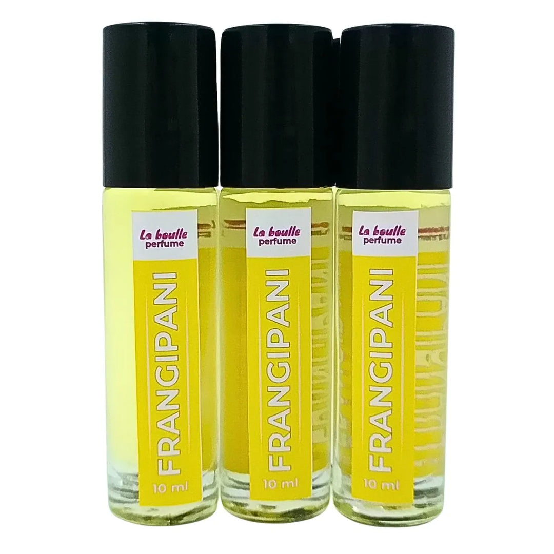 Set of three Frangipani perfume roll-on bottles La Boulle with yellow labels and black caps on a white background
