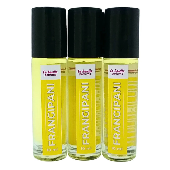 Set of three Frangipani perfume roll-on bottles La Boulle with yellow labels and black caps on a white background