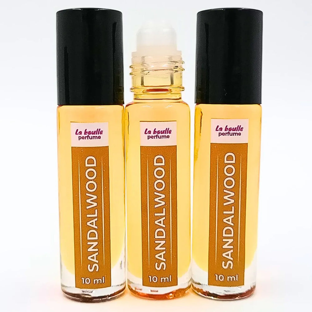 Sandalwood roll-on perfume bottles La Boulle with black caps on a white background